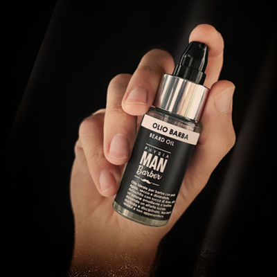 immagine con una mano su sfondo bianco e tra le dita il prodotto olio barba